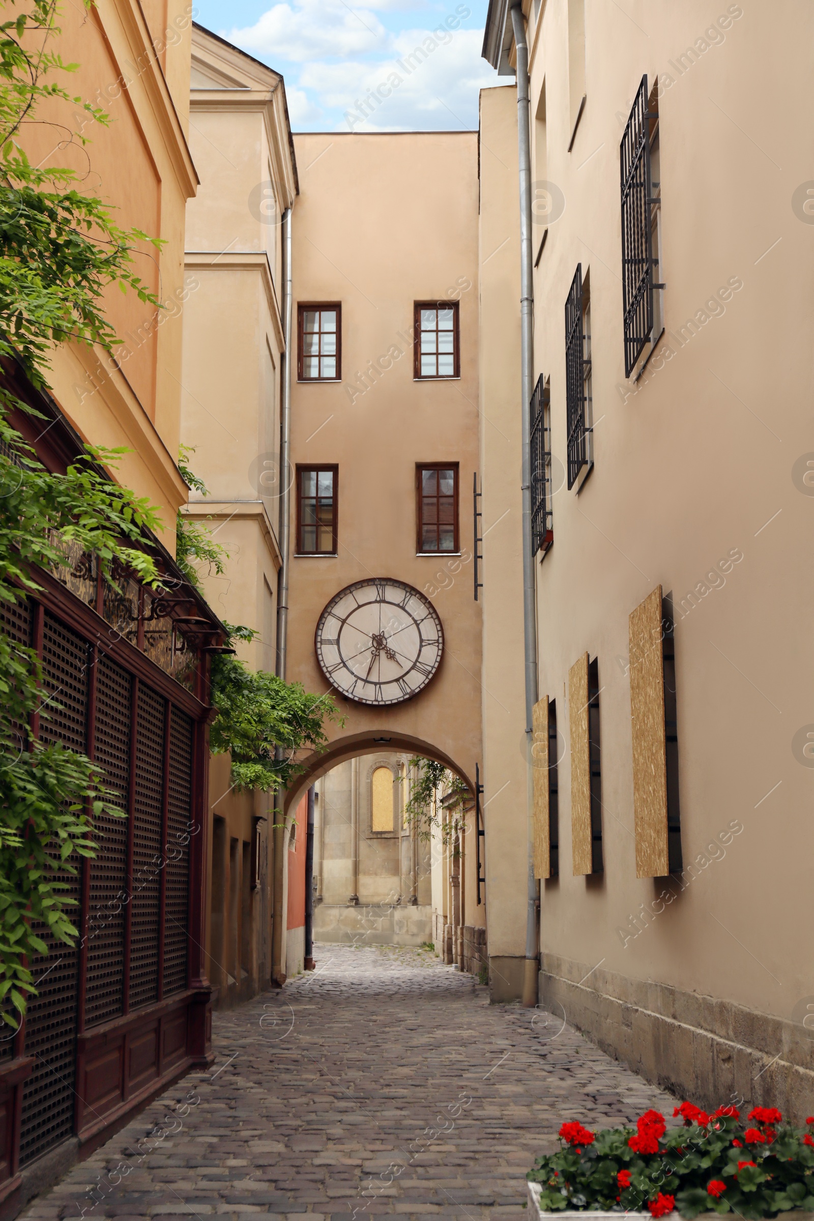 Photo of Narrow city street with beautiful buildings and clock