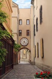 Narrow city street with beautiful buildings and clock