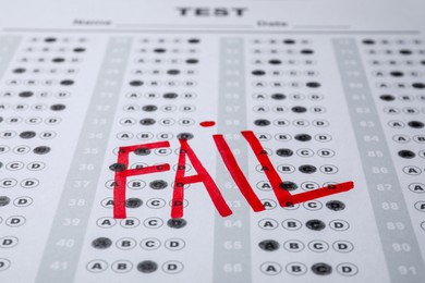 Word Fail written with red marker on answer sheet, closeup. Student passing exam