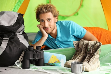 Young man in sleeping bag inside of tent