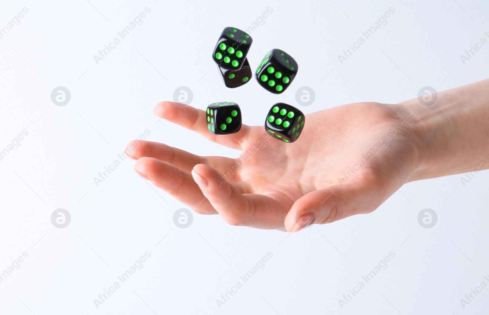 Photo of Woman throwing game dices on white background, closeup