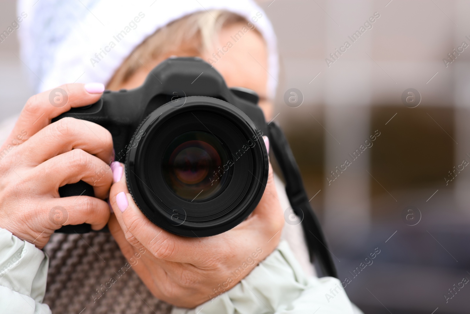 Photo of Photographer taking photo outdoors, focus on camera