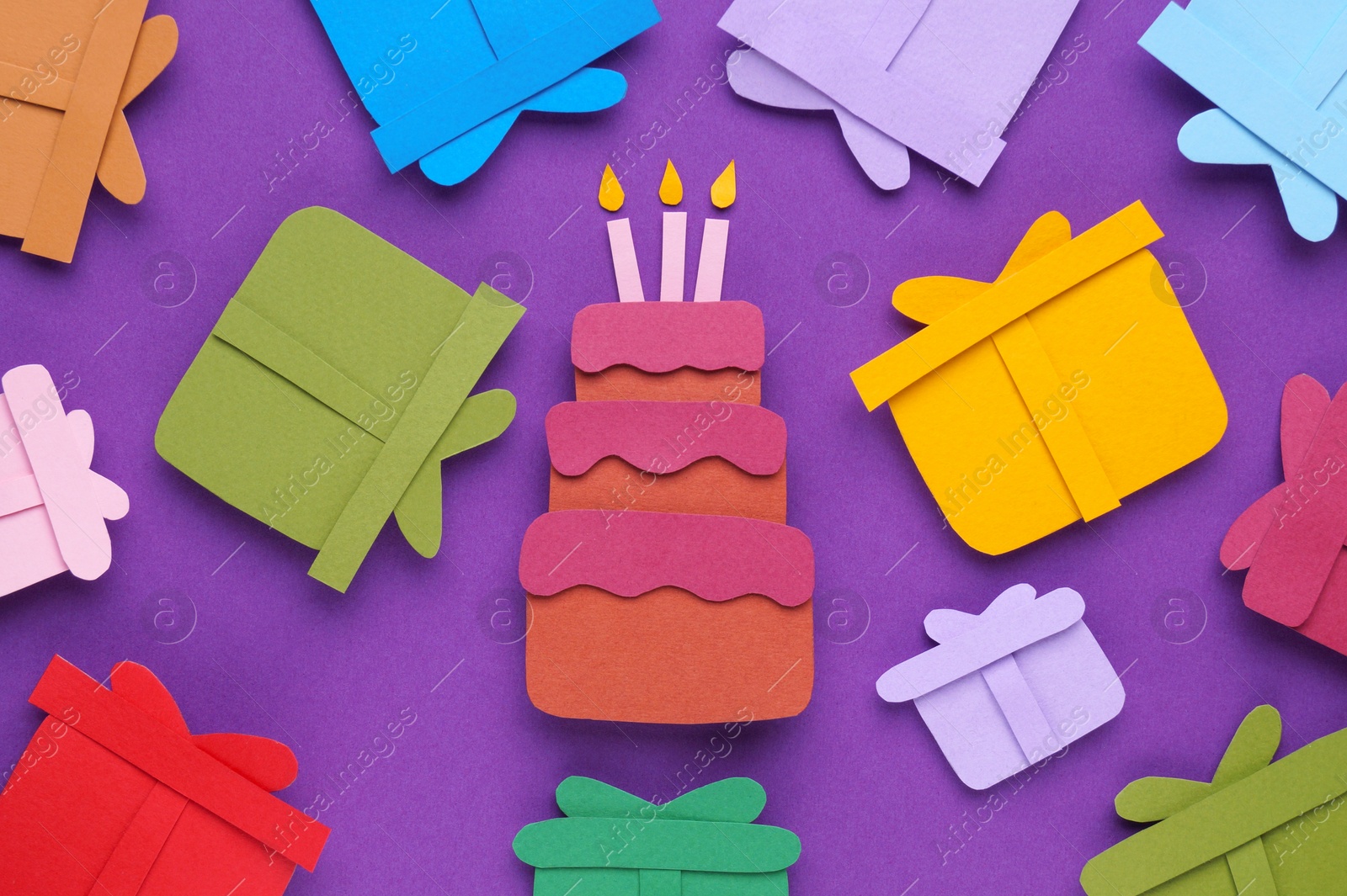 Photo of Birthday party. Paper cake and gifts on purple background, flat lay