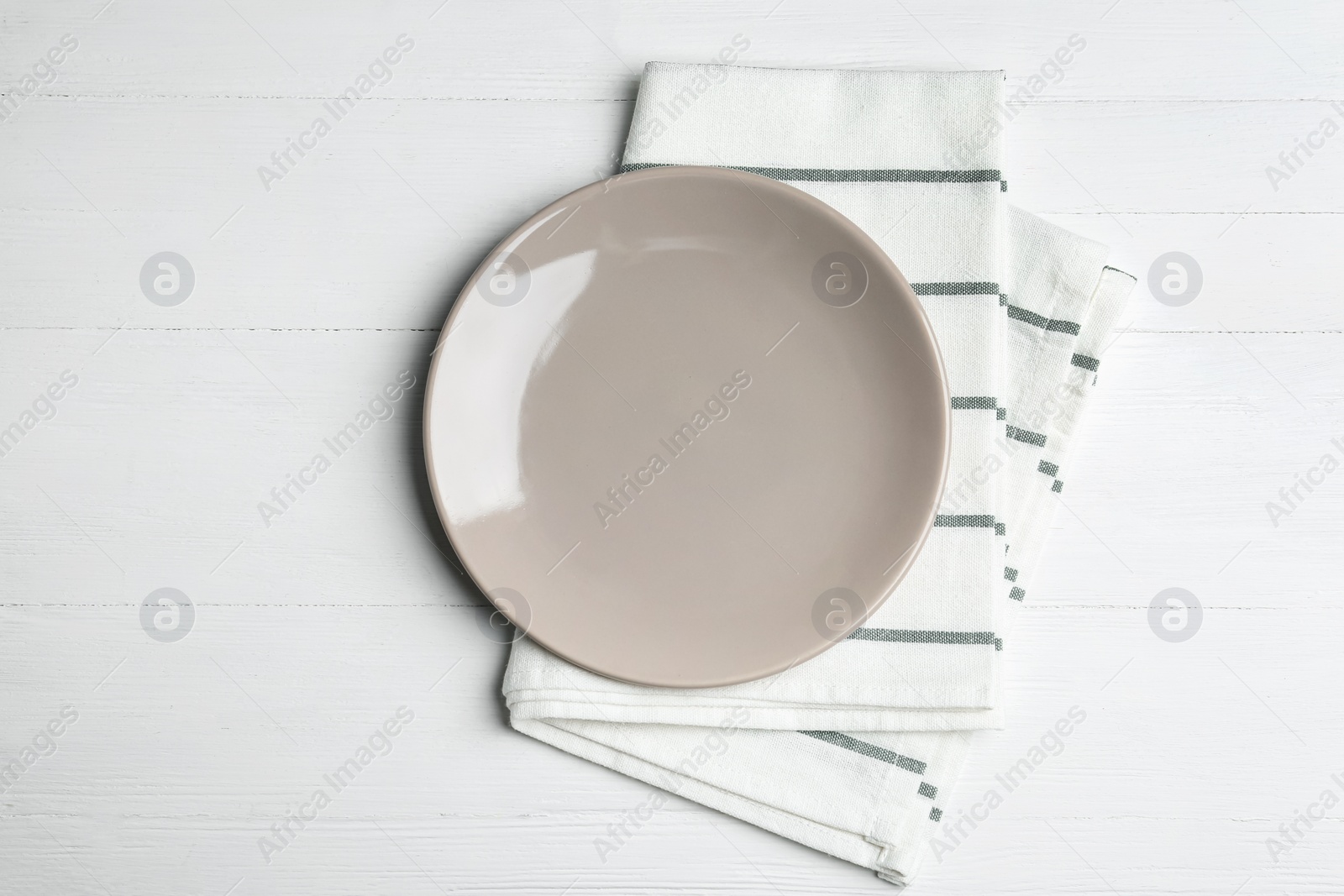 Photo of Empty grey plate and napkin on white wooden table, flat lay