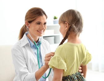 Photo of Children's doctor examining little girl at home. House call