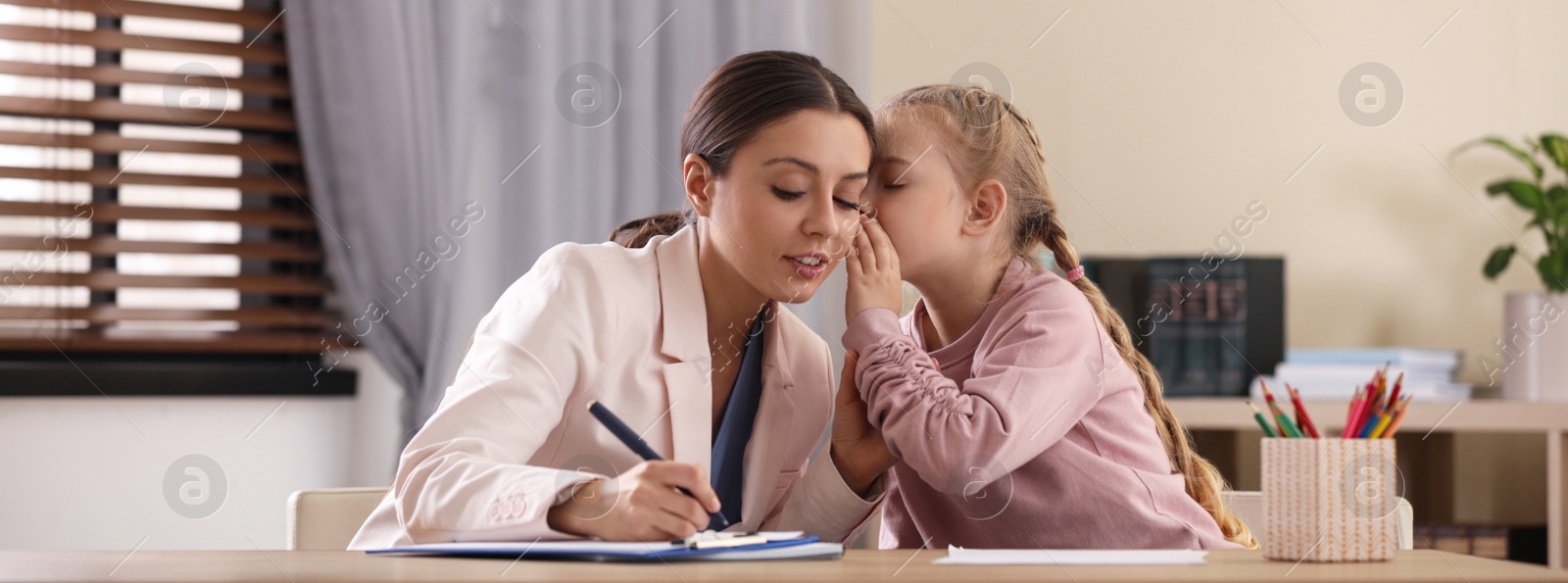 Image of Child psychotherapist working with little girl in office