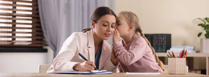 Image of Child psychotherapist working with little girl in office