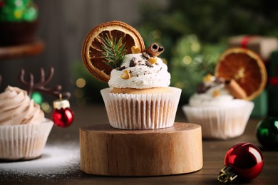 Photo of Delicious cupcakes and Christmas decor on wooden table