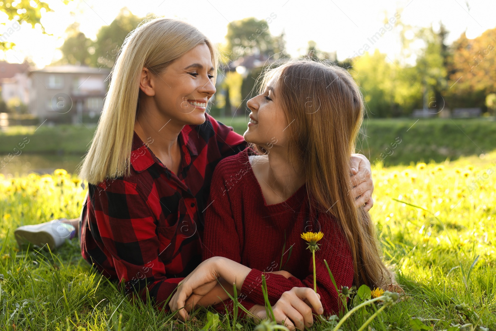 Photo of Happy mother with her daughter on green grass in park