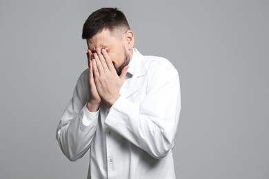 Photo of Portrait of doctor feeling fear on grey background