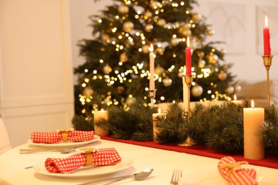 Festive table setting and beautiful Christmas decor in room. Interior design
