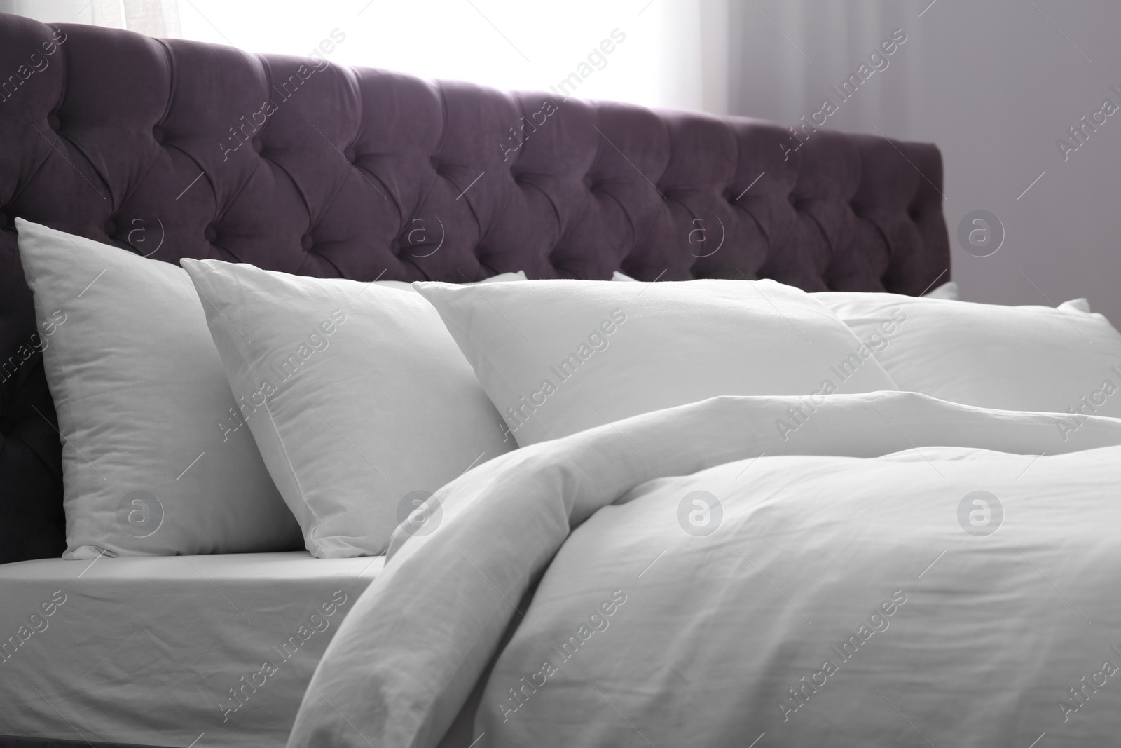 Photo of Modern bed with soft pillows in room