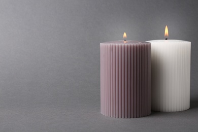 Photo of Burning candles on grey background. Space for text