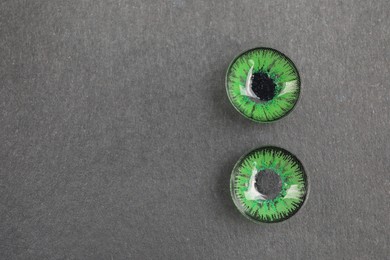 Photo of Pair of green contact lenses on black background, top view. Space for text