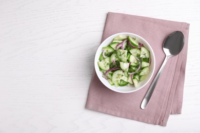 Photo of Flat lay composition with delicious fresh cucumber onion salad on table, space for text