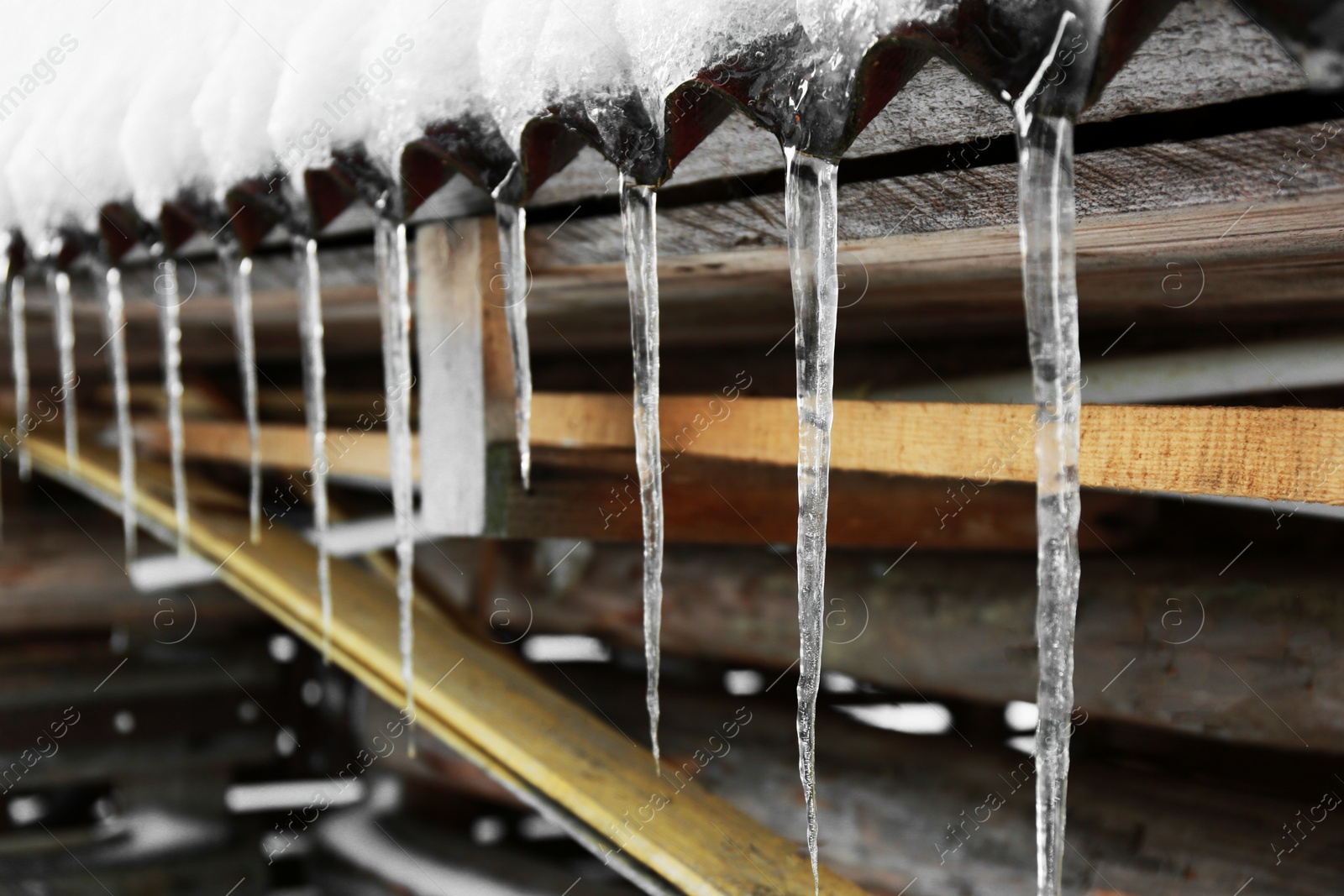 Photo of House with icicles on roof, closeup. Winter season