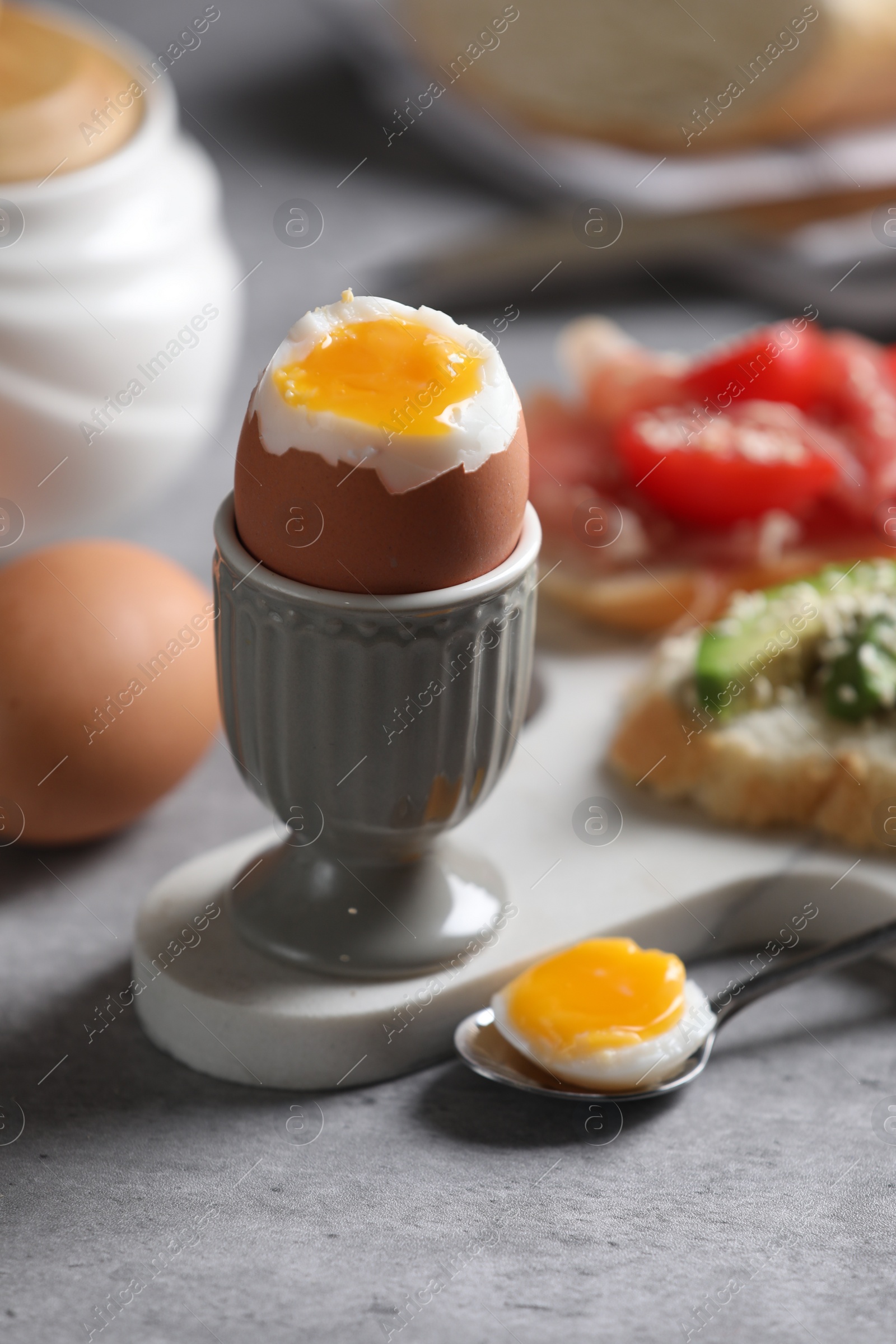 Photo of Tasty boiled chicken egg served for breakfast on light grey table