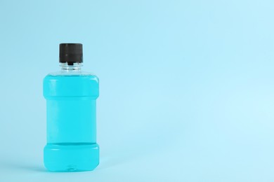 Photo of Mouthwash on light blue background, space for text