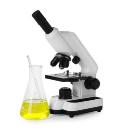 Laboratory flask with yellow liquid and microscope isolated on white