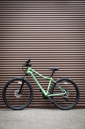 New modern color bicycle near brown wall outdoors