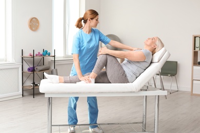 Photo of Physiotherapist working with patient in clinic. Rehabilitation therapy