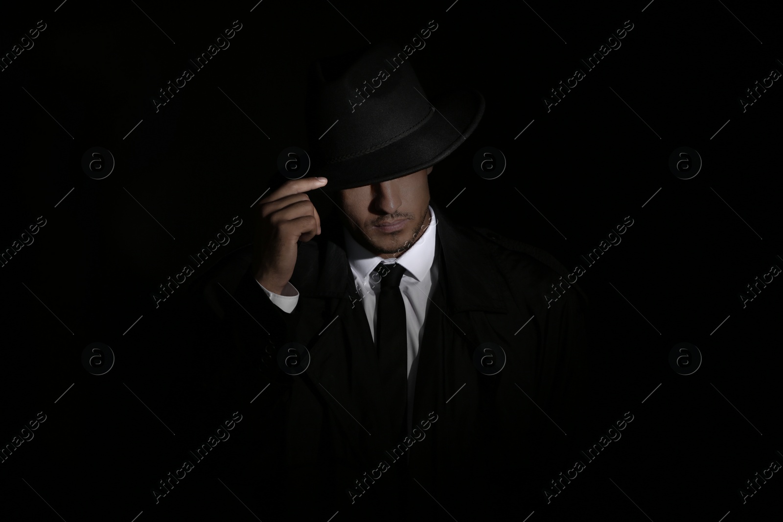 Photo of Old fashioned detective in hat on dark background