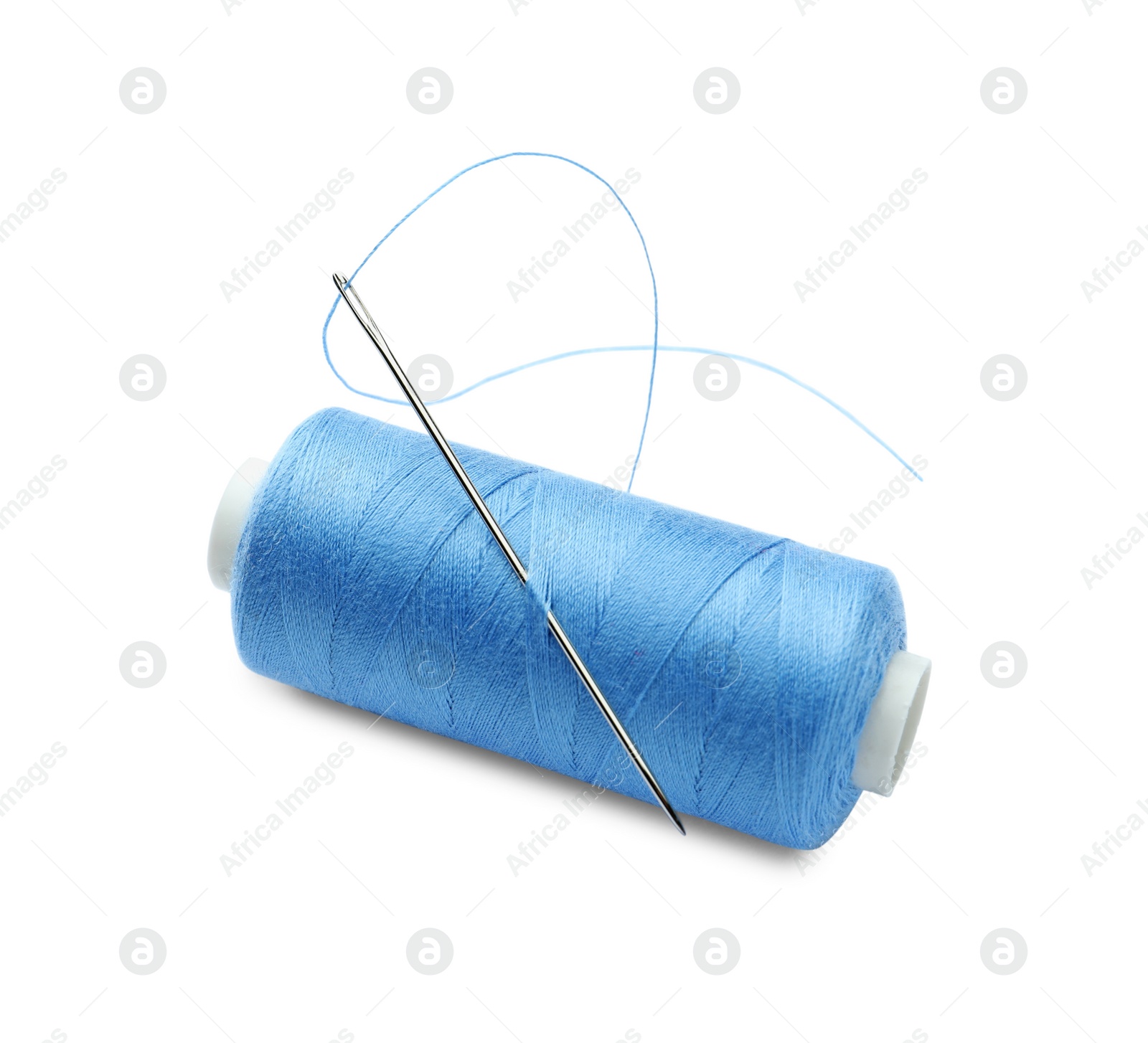Photo of Spool of light blue sewing thread with needle isolated on white