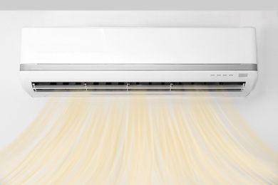 Image of Modern air conditioner on white wall indoors