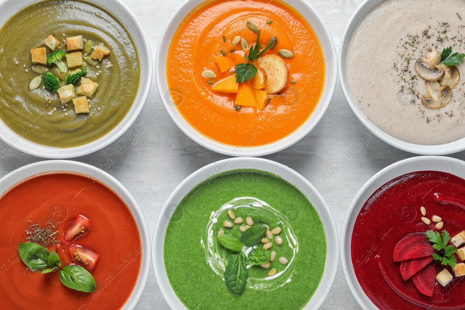 Photo of Various soups in bowls on wooden background, top view. Healthy food