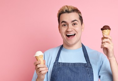Photo of Portrait of happy confectioner holding ice cream cones on pink background