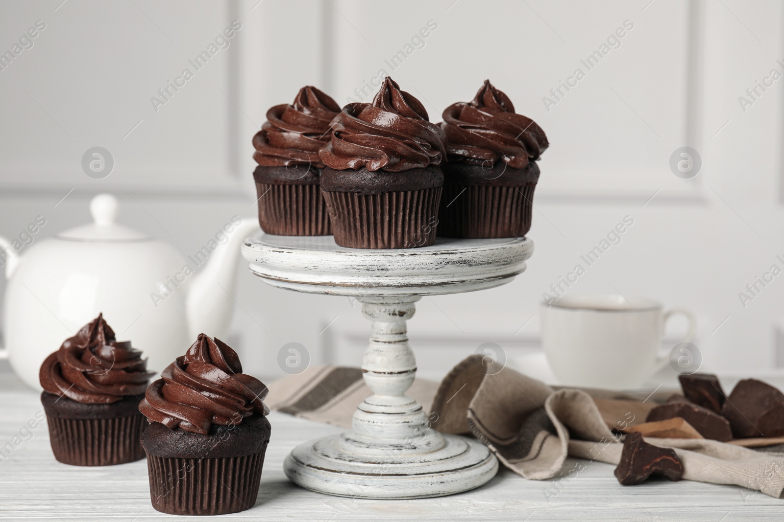 Photo of Delicious chocolate cupcakes with cream on white wooden table