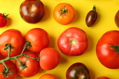 Flat lay composition with fresh ripe tomatoes on yellow background