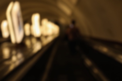 Blurred view of long escalator in underground subway. Bokeh effect