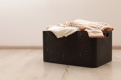 Photo of Laundry basket with dirty clothes on floor