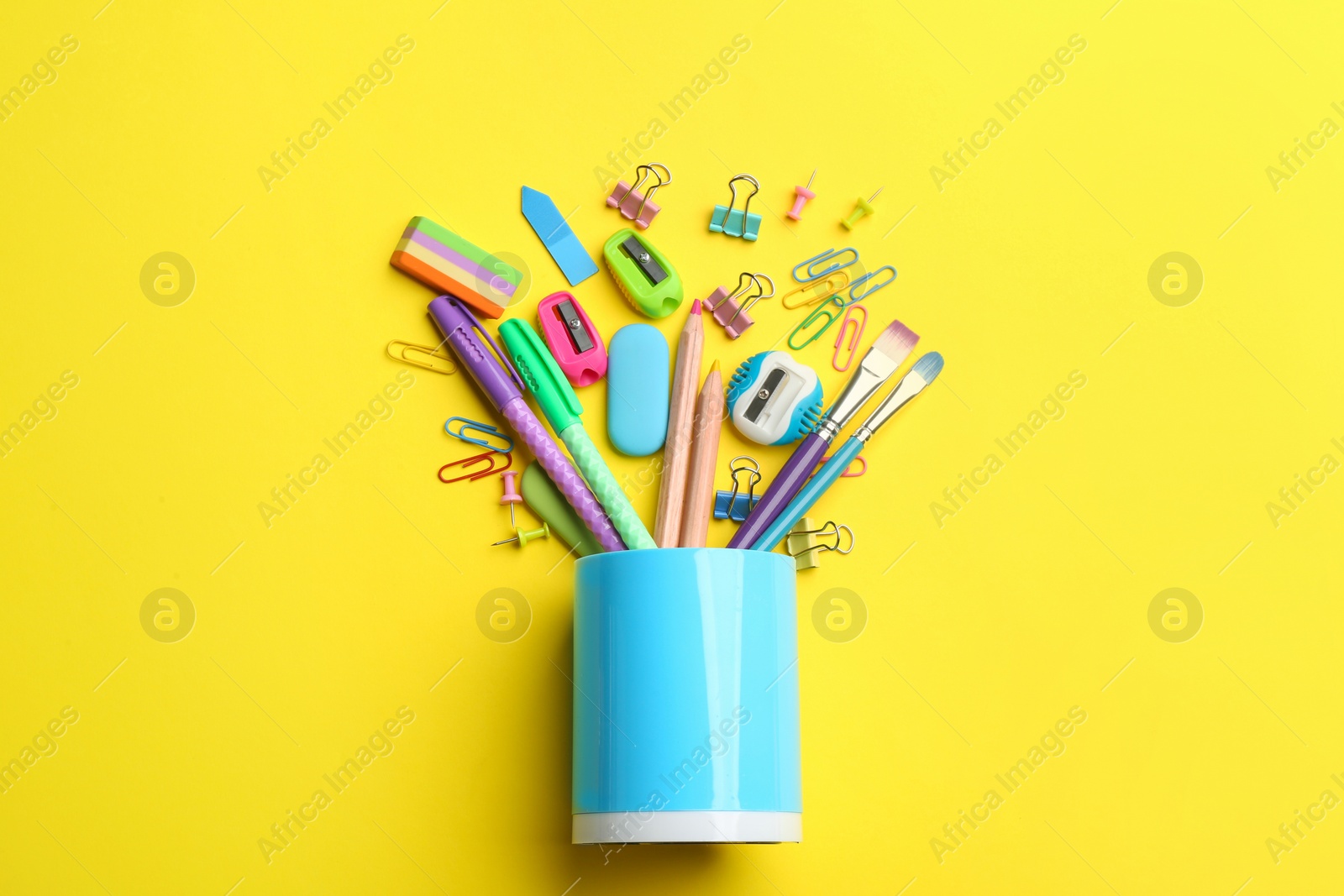 Photo of Flat lay composition with school stationery on yellow background. Back to school