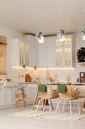 Photo of Cozy open plan kitchen decorated for Christmas. Interior design