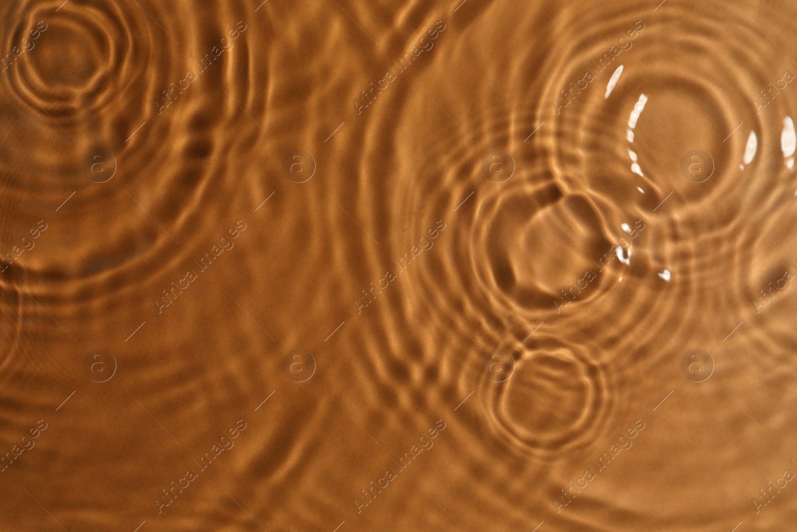Photo of Closeup view of water with circles on brown background