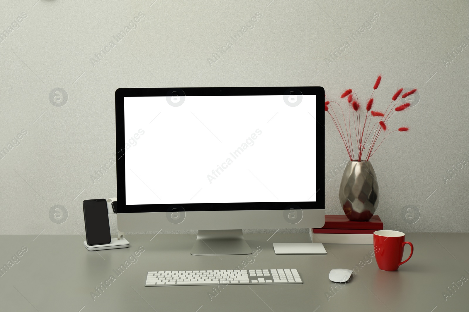 Photo of Modern workplace with computer and charging devices. Interior design