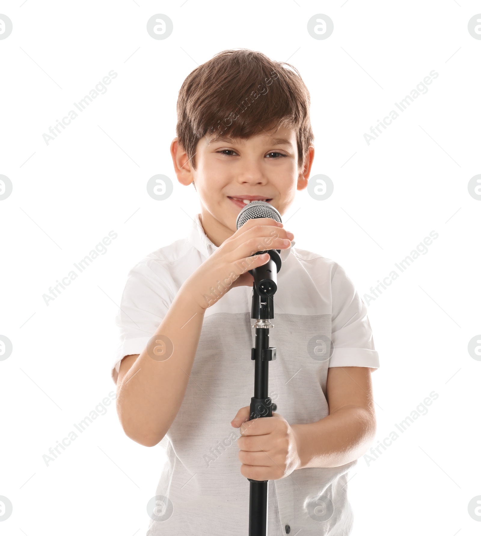 Photo of Cute little boy singing into microphone on white background