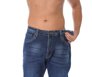 Fit man in oversized jeans on white background, closeup. Weight loss