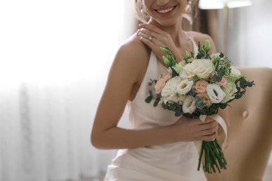 Photo of Young bride with beautiful wedding bouquet indoors, closeup