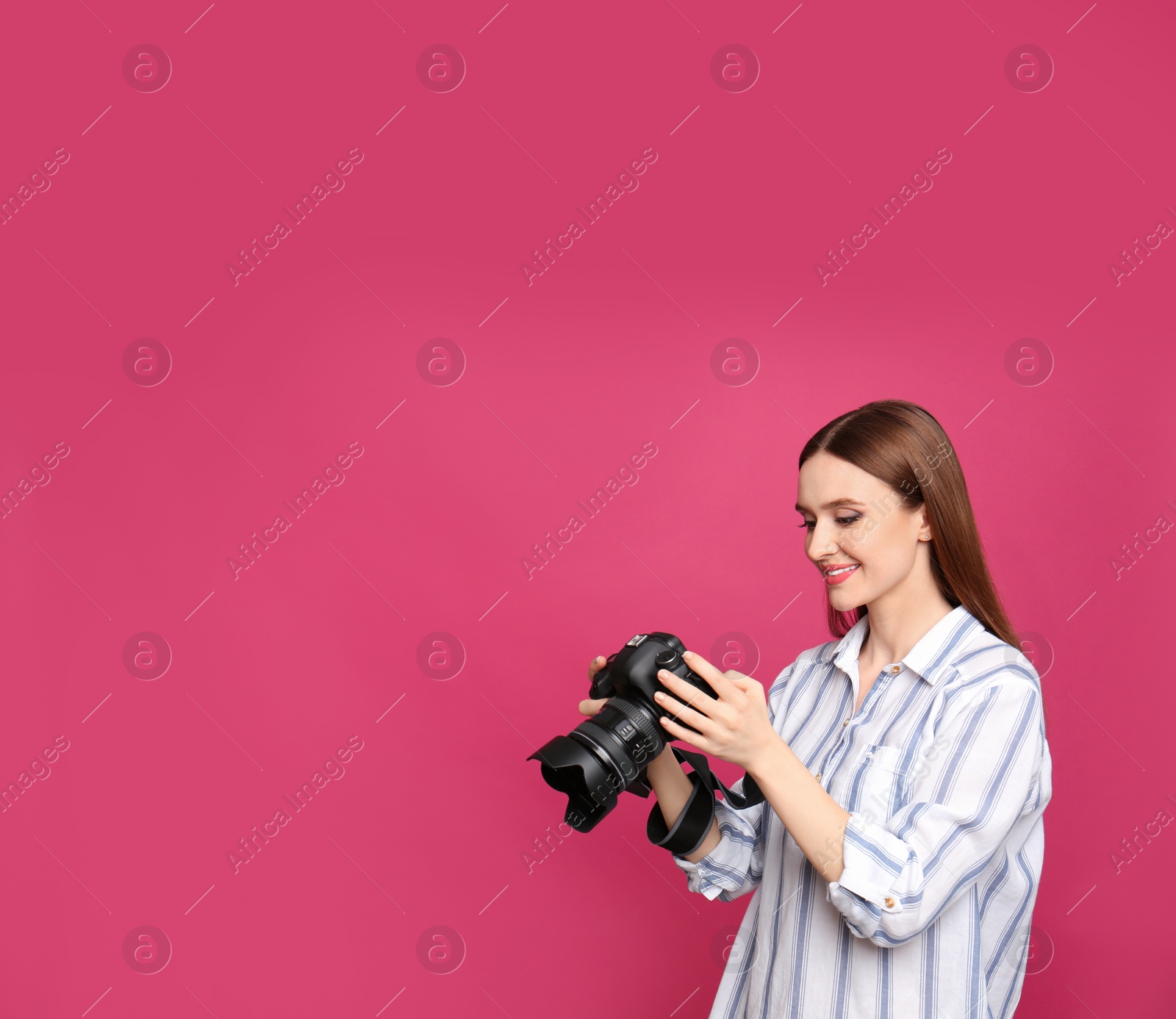 Photo of Professional photographer with modern camera on pink background. Space for text