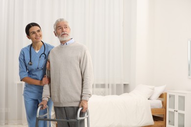 Photo of Smiling nurse supporting elderly patient in hospital. Space for text