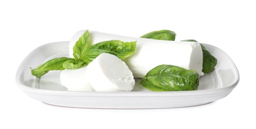 Photo of Delicious goat cheese with basil on white background