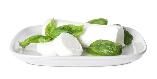 Delicious goat cheese with basil on white background