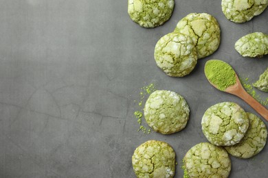 Tasty matcha cookies and wooden spoon of powder on grey table, flat lay. Space for text