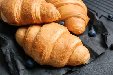 Photo of Tasty croissants on table, closeup