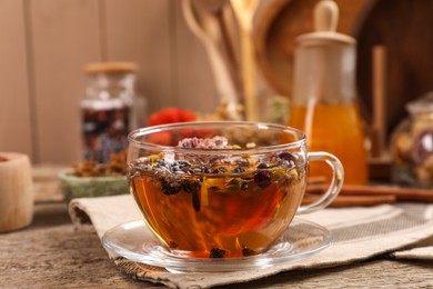 Aromatic tea with different dry herbs and flowers on wooden table, closeup