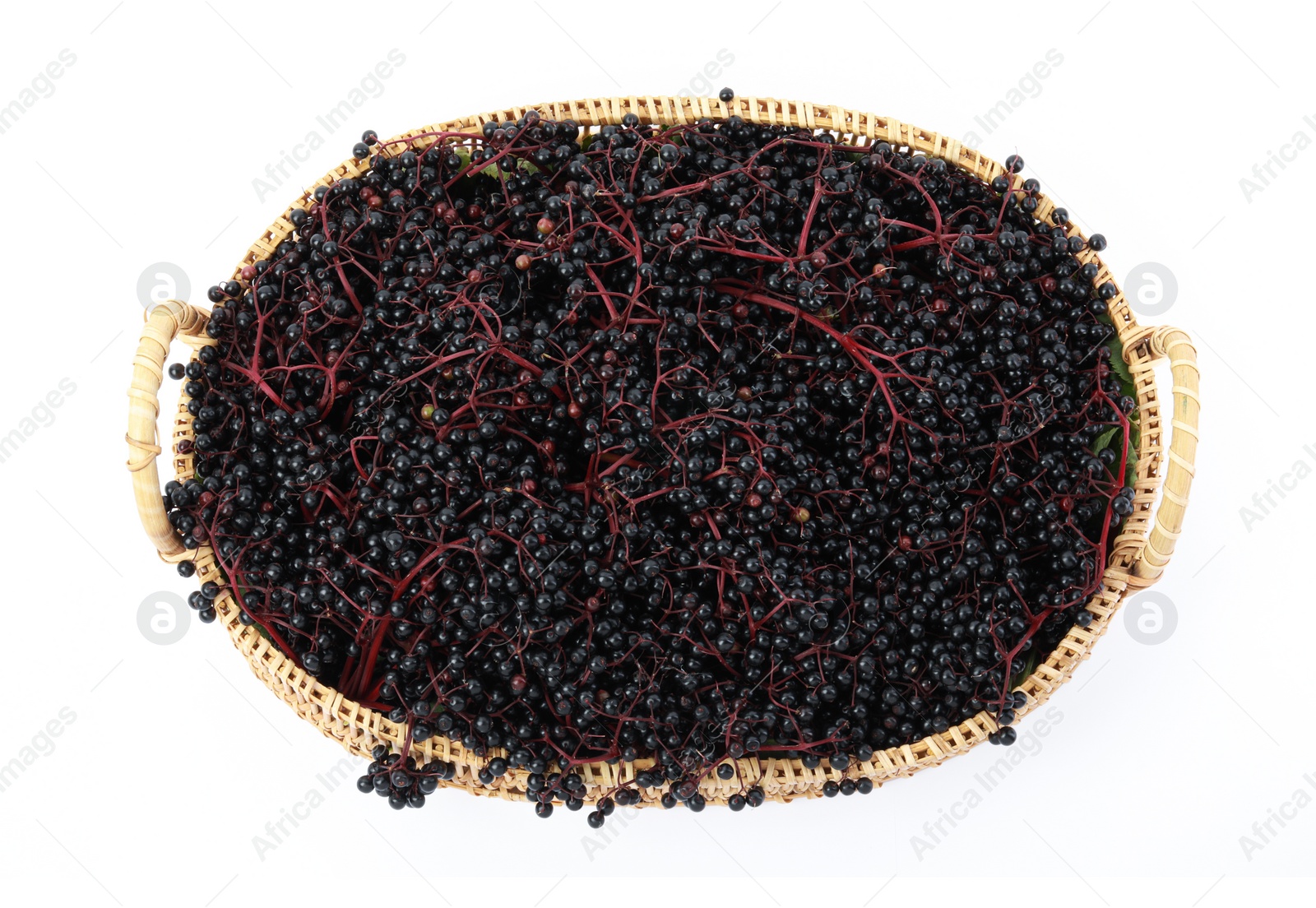 Photo of Wicker basket with ripe elderberries isolated on white, top view