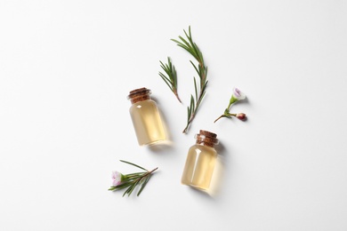 Photo of Flat lay composition with bottles of natural tea tree oil on white background